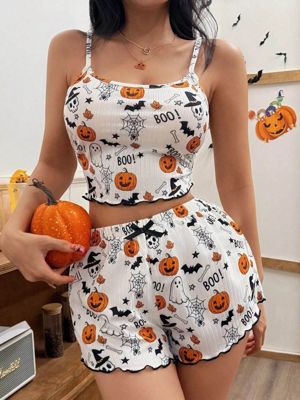 Woman wearing white pumpkin print Halloween loungewear set with cami top and shorts